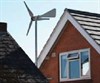 Photograph of a small wind turbine on the roof of a house